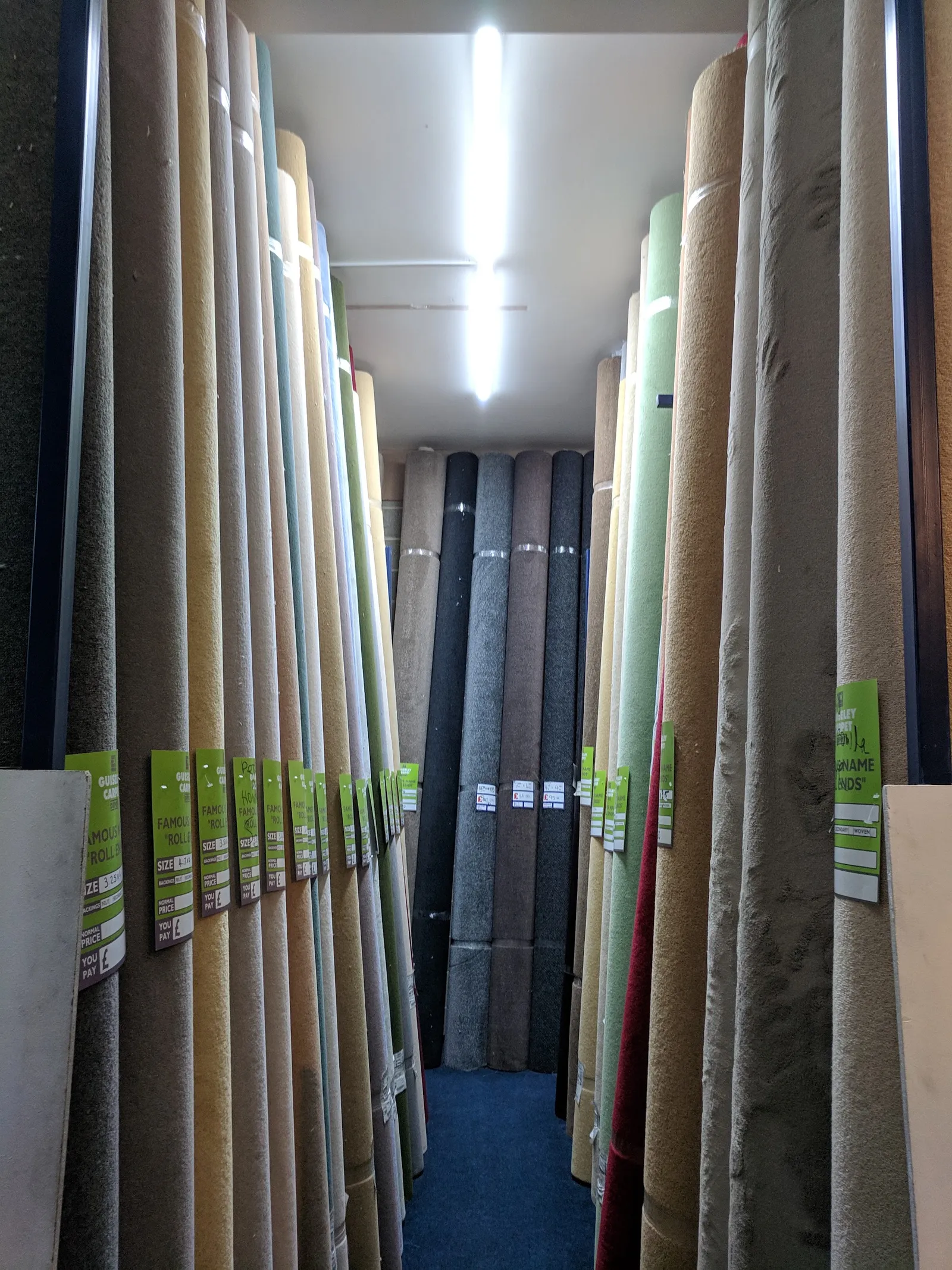 Rows of carpet rolls in different colours inside Guiseley Carpets